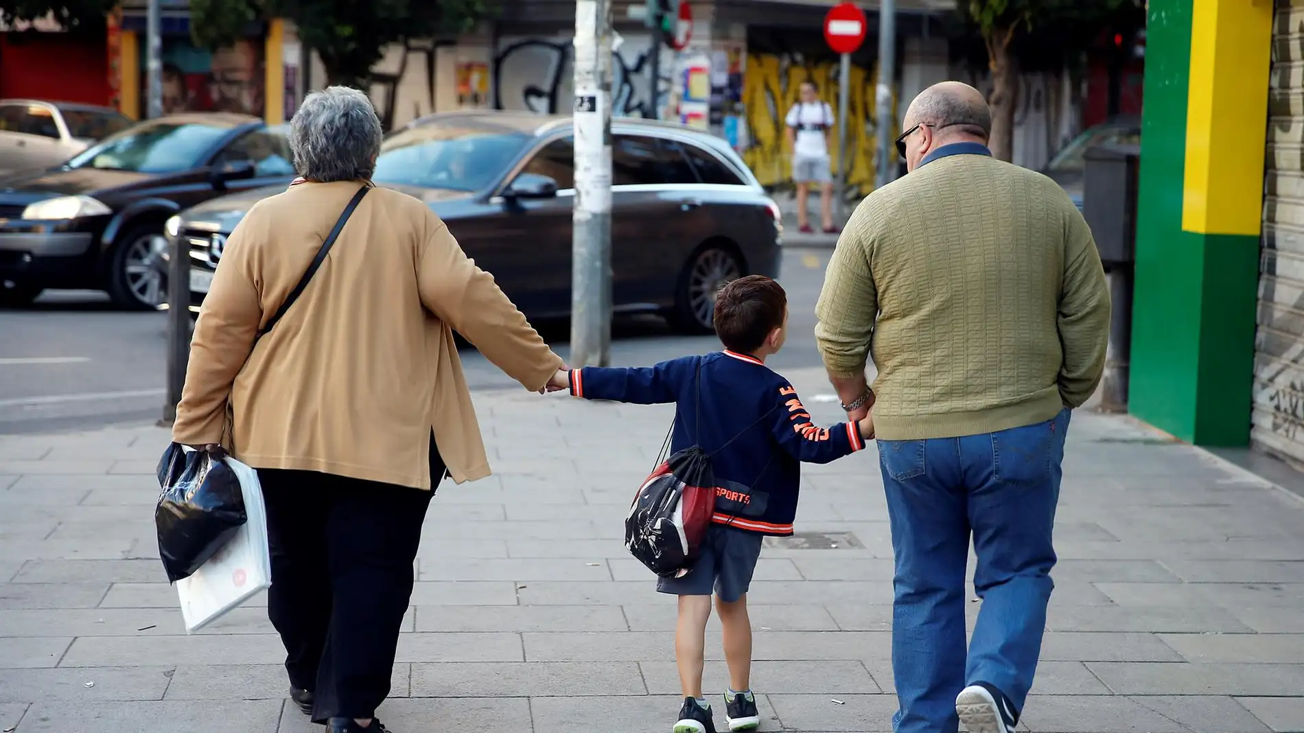 Un niño va al colegio con sus abuelos en una imagen de archivo