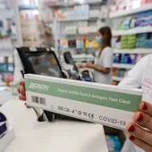 Imagen de archivo de una farmacéutica dispensando un test de antígenos Imagen de archivo de una farmacéutica dispensando un test de antígenos