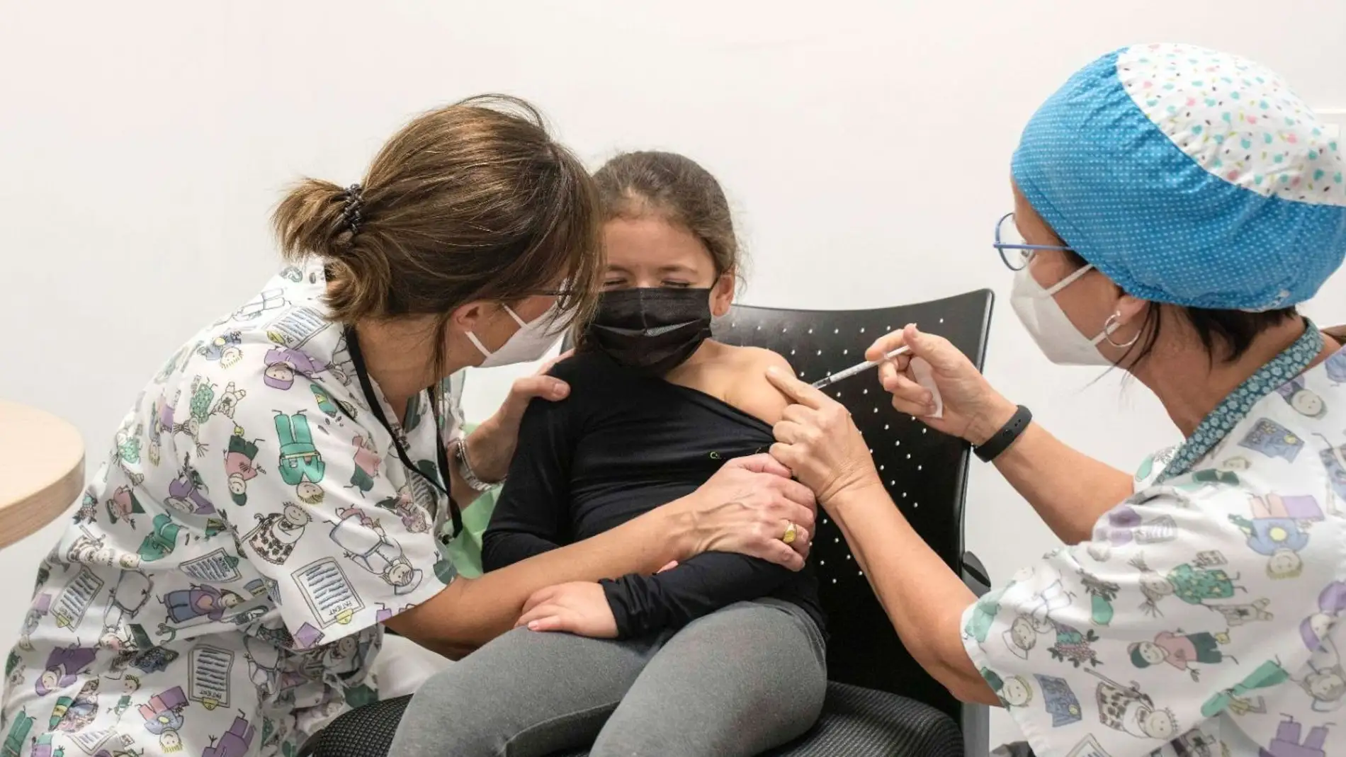 Una niña es vacunada por personal pediátrico. 
