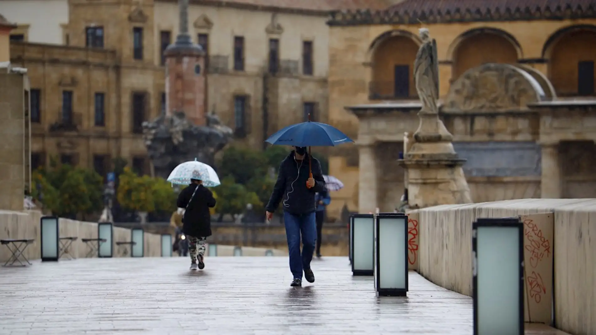 Imagen de archivo de dos personas paseando bajo la lluvia en Córdoba