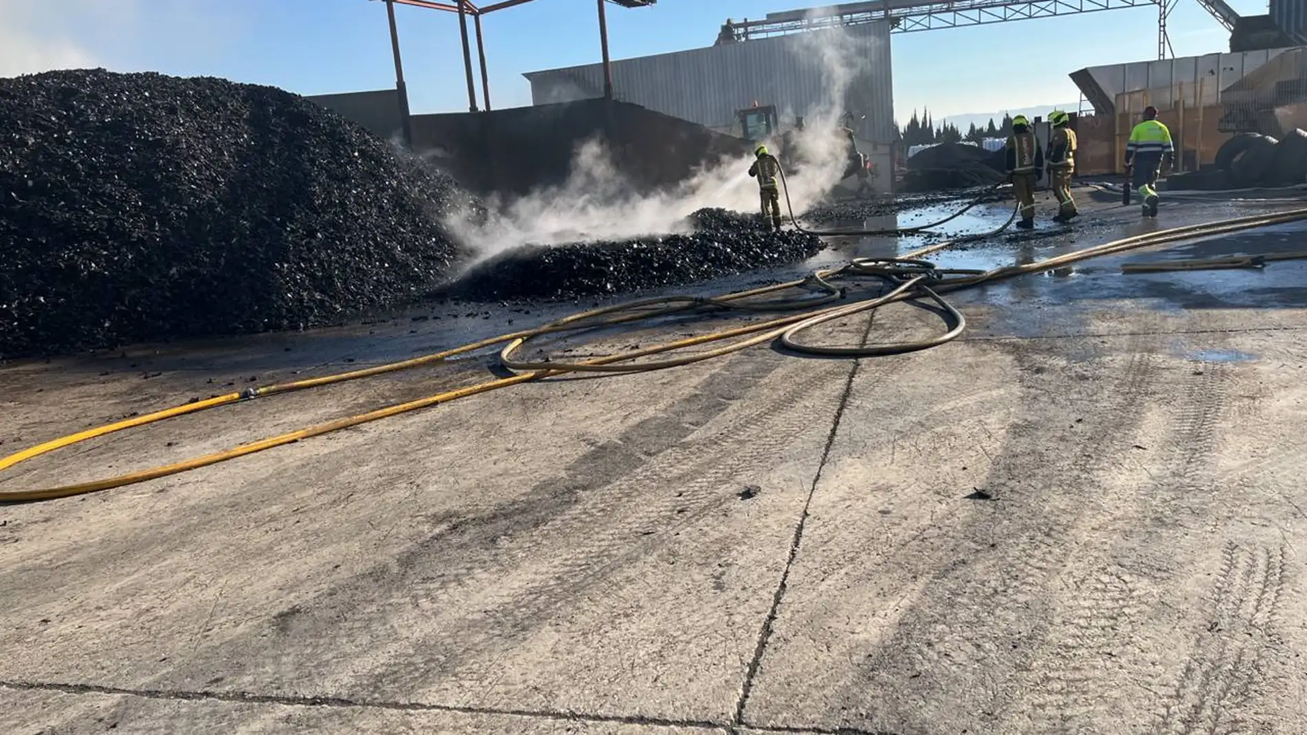 Efectivos de Bomberos siguen trabajando en la extinción total del incendio del almacén de neumáticos que ardió este domingo en Aspe