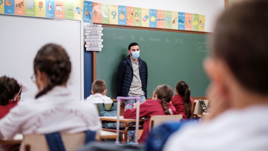 Un profesor da clase con mascarilla a un grupo de ni&ntilde;os