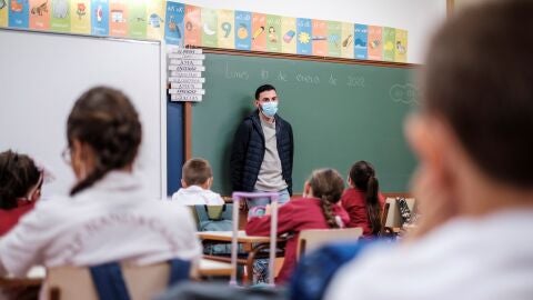 Un profesor da clase con mascarilla a un grupo de ni&ntilde;os