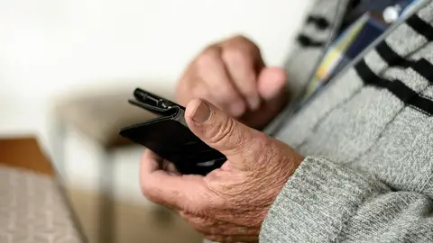 Persona mayor utilizando un teléfono móvil Persona mayor utilizando un teléfono móvil