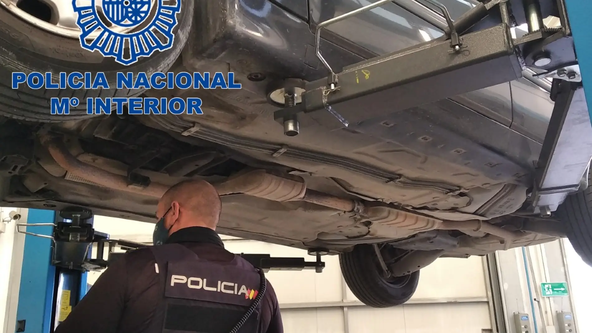 Agente de la Policía Nacional inspecciona los bajos de un coche.