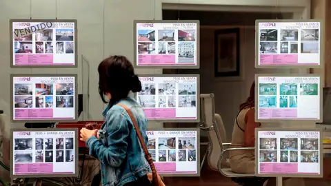 Imagen de archivo de una persona mirando ofertas de viviendas en una inmobiliaria. Imagen de archivo de una persona mirando ofertas de viviendas en una inmobiliaria.