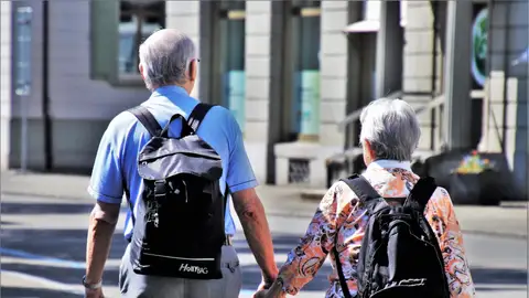 Una pareja de jubilados paseando de la mano