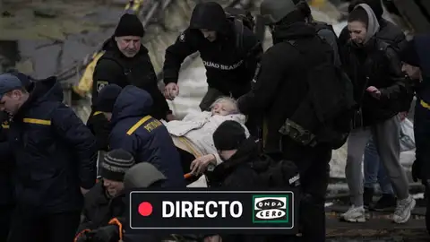 Guerra Ucrania Rusia, en directo: ataques de Putin a Kiev, la respuesta de Zelenski, subida de la gasolina y la luz y últimas noticias de hoy Un grupo de gente lleva a una anciana en Kiev/ Gtres