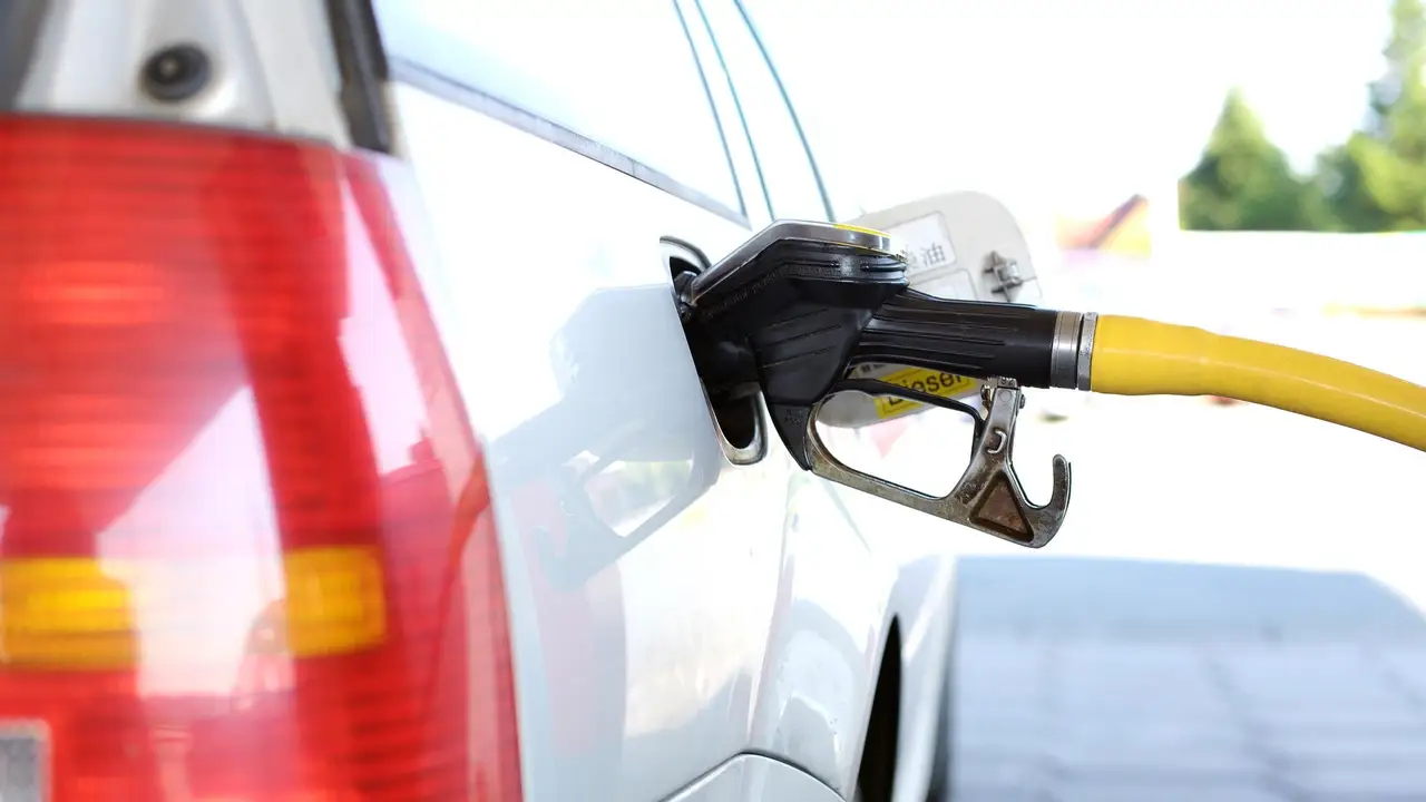 Un coche repostando gasolina Un coche repostando gasolina