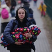 Mujer refugiada huye con su bebé
