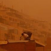 Trabajadores en Roquetas del Mar, Almería, que ha amanecido cubierta de polvo sahariano