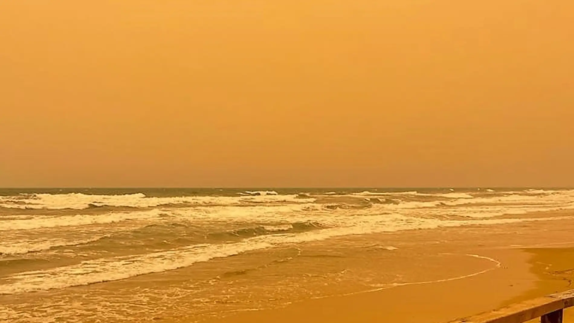 La calima deja el cielo de color sepia en la playa de Arenales del Sol de Elche