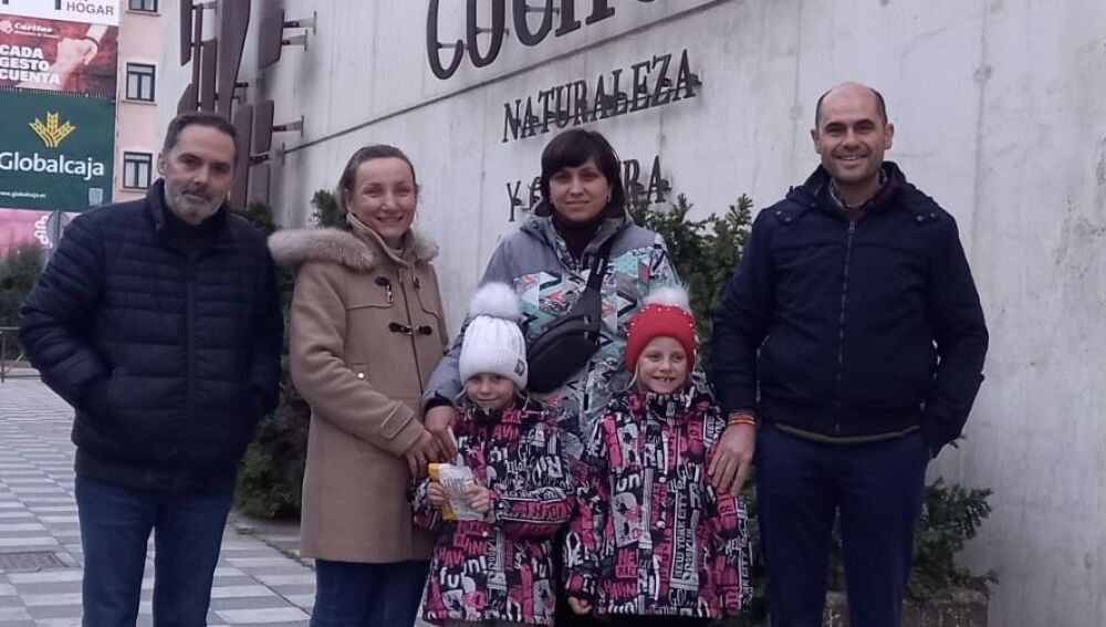 Diana y Milana, dos gemelas ucranianas junto a su madre, el pasado viernes a su llegada a la capital, donde las esperaban  Mariano Latorre y Nacho Pérez 