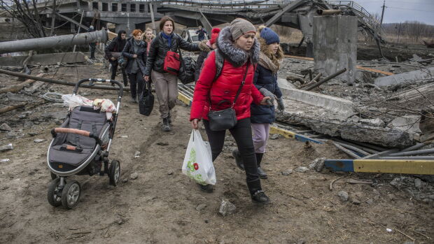 Ciudadanos ucranianos huyen de una ciudad bombardeada