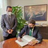 Álvaro López Dapena firma en el libro de honor del puerto en presencia de Julián López Milla