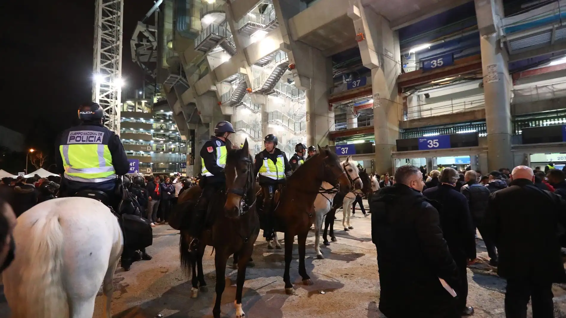 Varios policías vigilan el comportamiento de aficionados presentes en el Bernabéu. / Efe