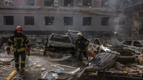 Bomberos ucranianos trabajan junto a edificios dañados en la zona que fue alcanzada por el bombardeo de artillería rusa, en Kharkiv, al noreste de Ucrania
