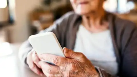 Persona mayor utilizando un teléfono móvil Persona mayor utilizando un teléfono móvil