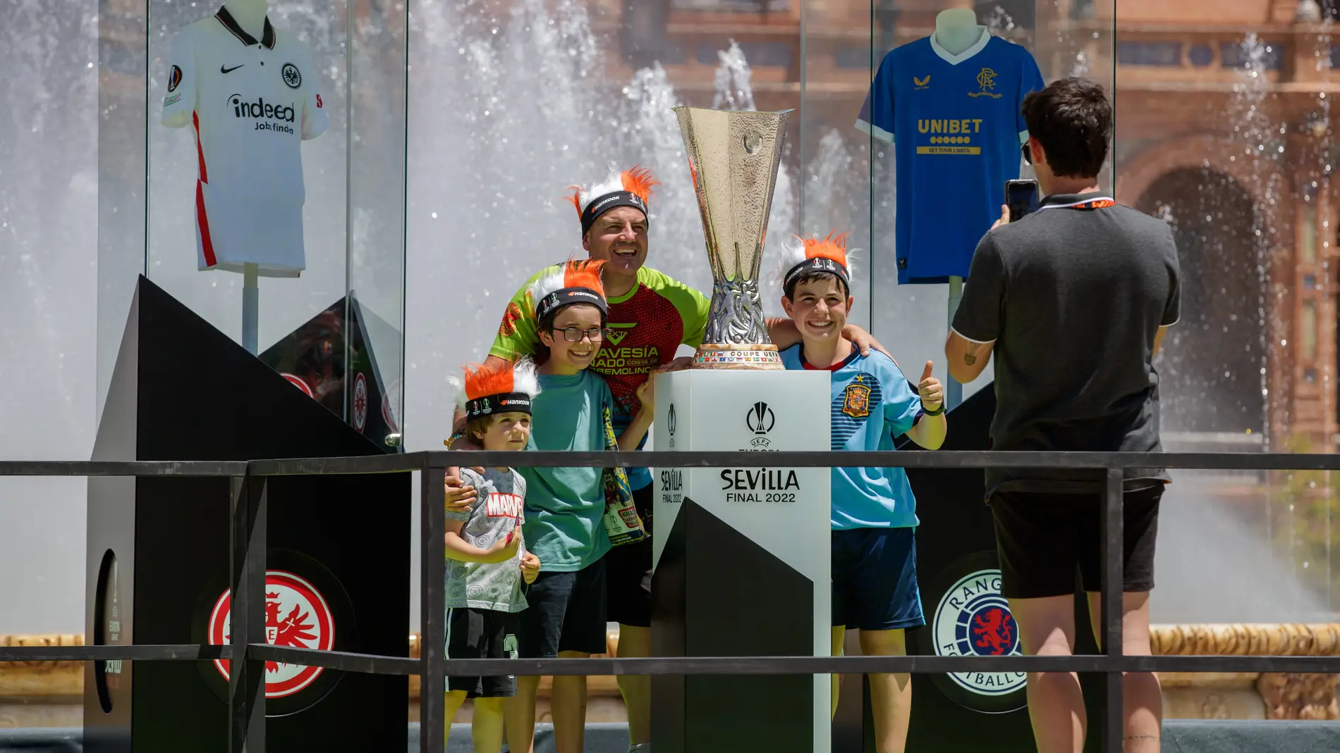  Aficionados se hacen fotos junto al trofeo de la Europa League en la Plaza de España de Sevilla.