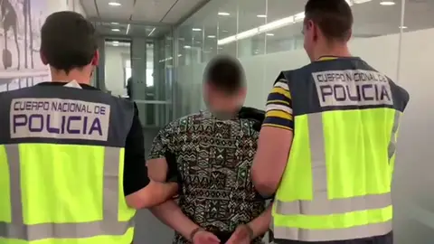 Agentes de la Policía Nacional con uno de los detenidos.