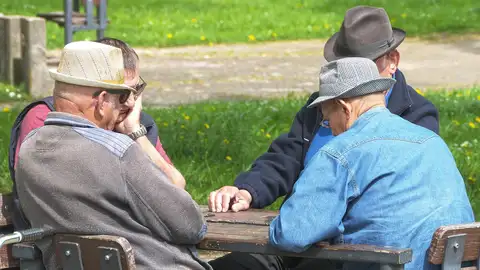 Un grupo de señores mayores jugando a las cartas
