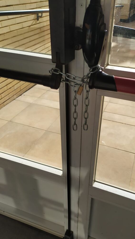 Puerta de salida al jardín de la residencia de Altabix con un candado.