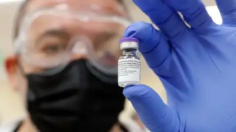 Un investigador sostiene una vacuna contra el coronavirus. Un investigador sostiene una vacuna contra el coronavirus.