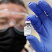 Un investigador sostiene una vacuna contra el coronavirus.