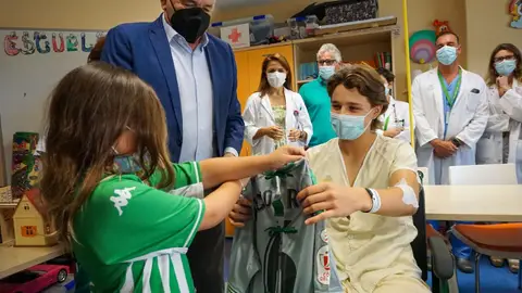 Varios niños reciben sus batas verdiblancas en el hospital.