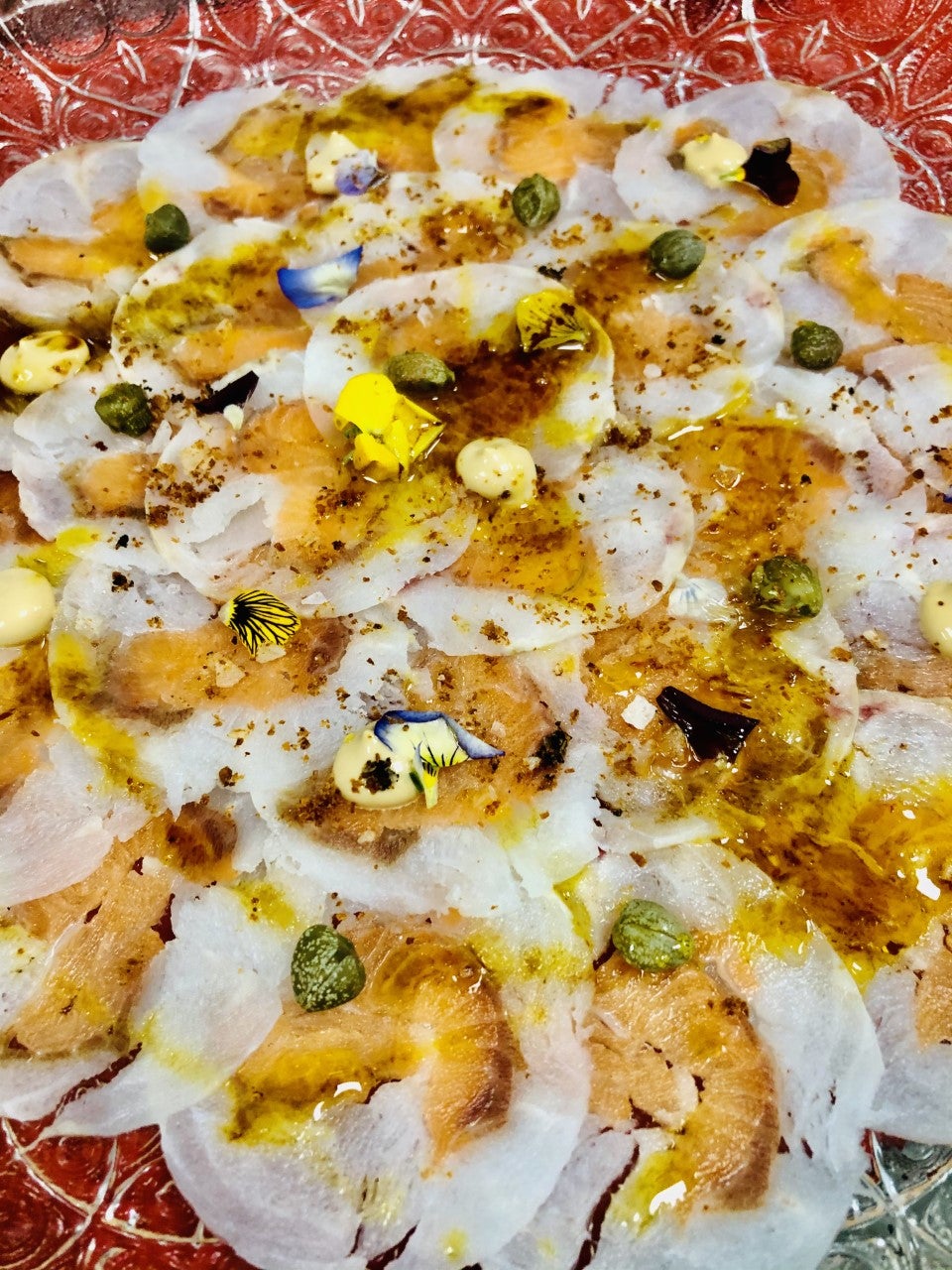 Carpaccio de merluza y salmón, crema de wasabi, sal de marisco y alcaparras Carpaccio de merluza y salmón, crema de wasabi, sal de marisco y alcaparras