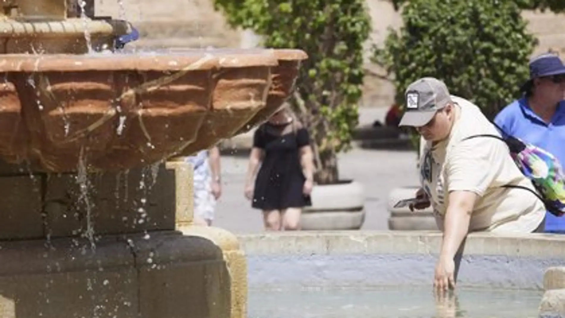 Hombre refrescándose debido a las altas temperaturas en Sevilla