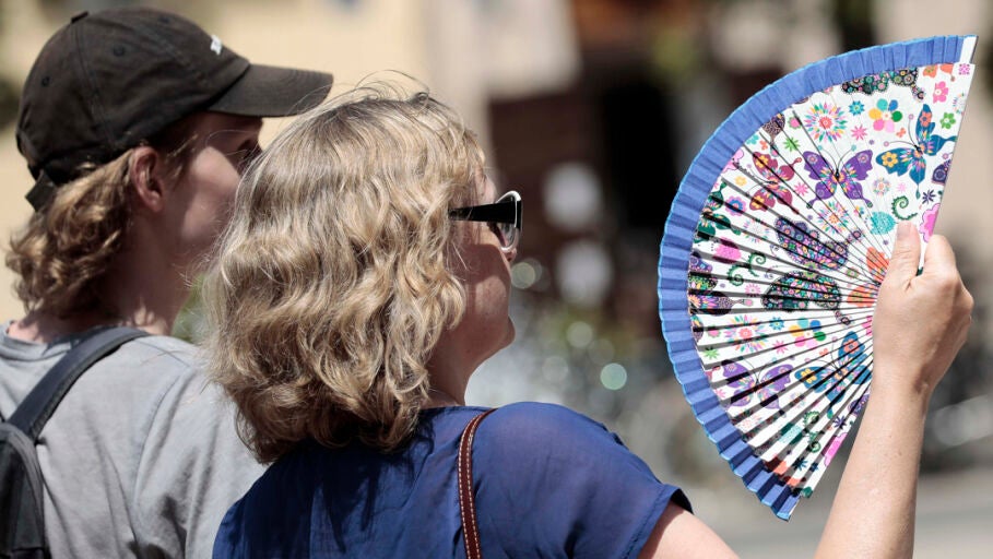 Dos personas se abanican para combatir el calor en Valencia/ EFE/Ana Escobar