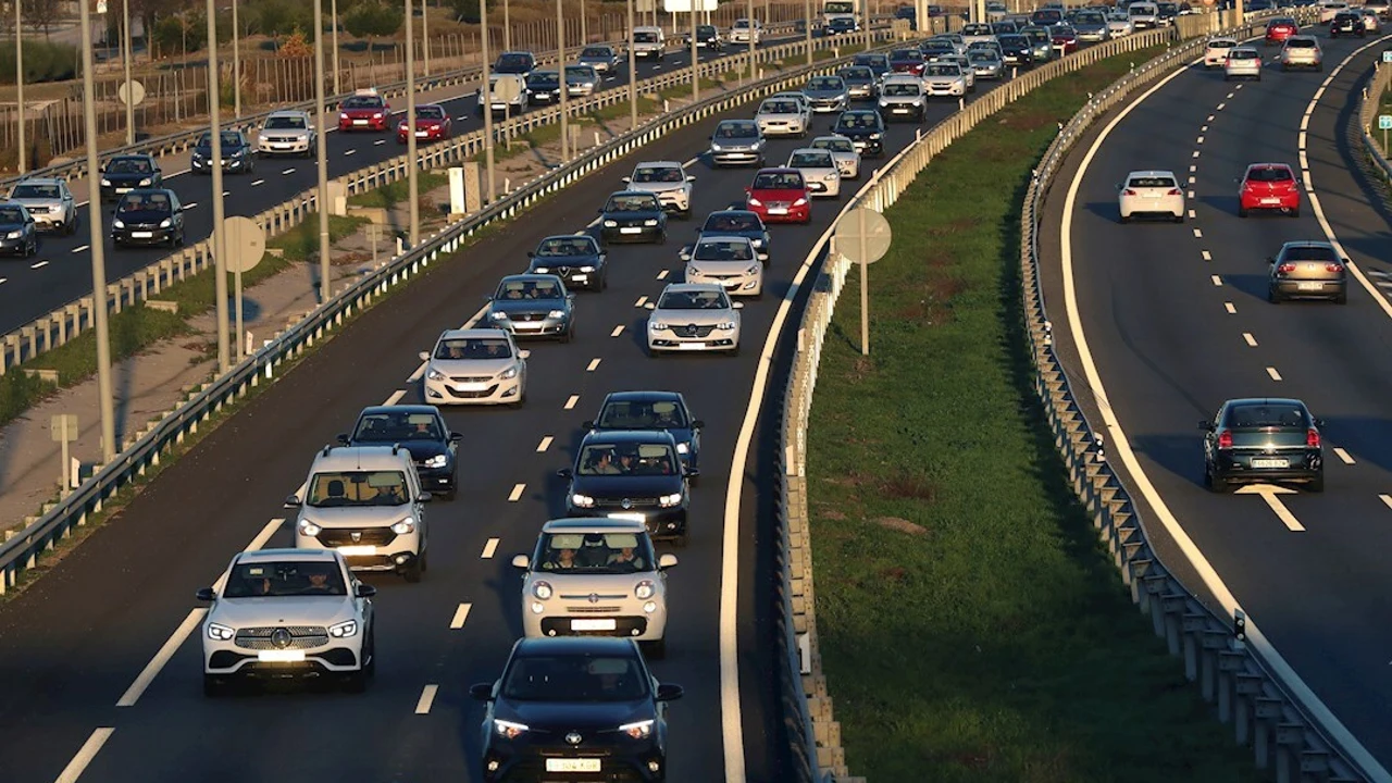 Varios coches circulan por carretera.