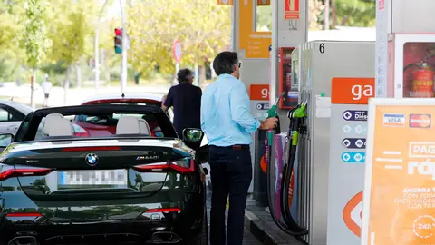 Unas personas repostan combustible en una gasolinera de Madrid Unas personas repostan combustible en una gasolinera de Madrid