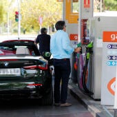 Unas personas repostan combustible en una gasolinera de Madrid