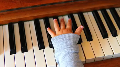 Imagen de la mano de un niño sobre un piano Imagen de la mano de un niño sobre un piano