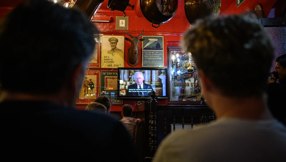 Clientes de un bar de Londres siguen con atención el primer discurso de Carlos III de Inglaterra
