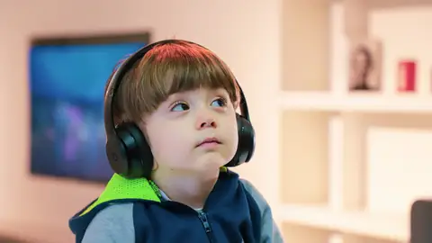 Imagen de archivo de un niño con trastorno del espectro autista (TEA) utilizando protectores auditivos