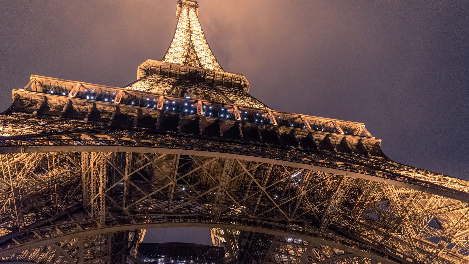Imagen de archivo de la Torre Eiffel iluminada, tomada desde el pie del monumento. / Unsplash