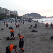 Operarios limpian la playa de El Postiguet el pasado mes de junio (archivo)