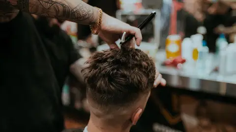 Un peluquero recorta el pelo a un hombre Un peluquero recorta el pelo a un hombre/ Unsplash