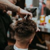 Un peluquero recorta el pelo a un hombre