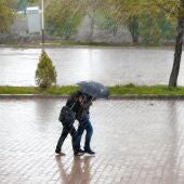 Gente caminando por la calle protegiéndose de la lluvia