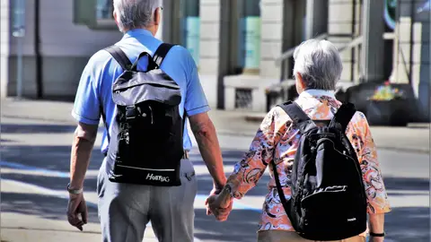 Una pareja pasea con sus mochilas Una pareja pasea con sus mochilas