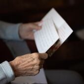 Una persona mayor lee una carta en una imagen de archivo