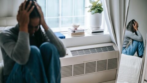 Imagen de archivo de una mujer con ambas manos en la cabeza/ Pexels