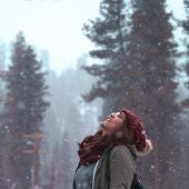Una mujer sonríe ante una nevada en una fotografía de archivo