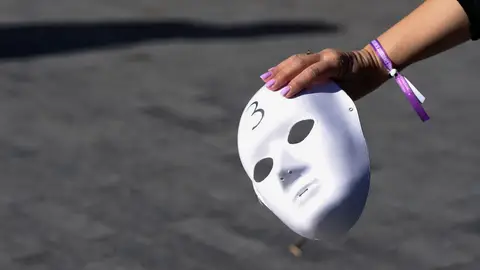 Una mujer sostiene una careta durante la concentración con motivo del 25N Una mujer sostiene una careta durante la concentración con motivo del 25N