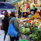 Varias personas hacen la compra en un mercado. Varias personas hacen la compra en un mercado.