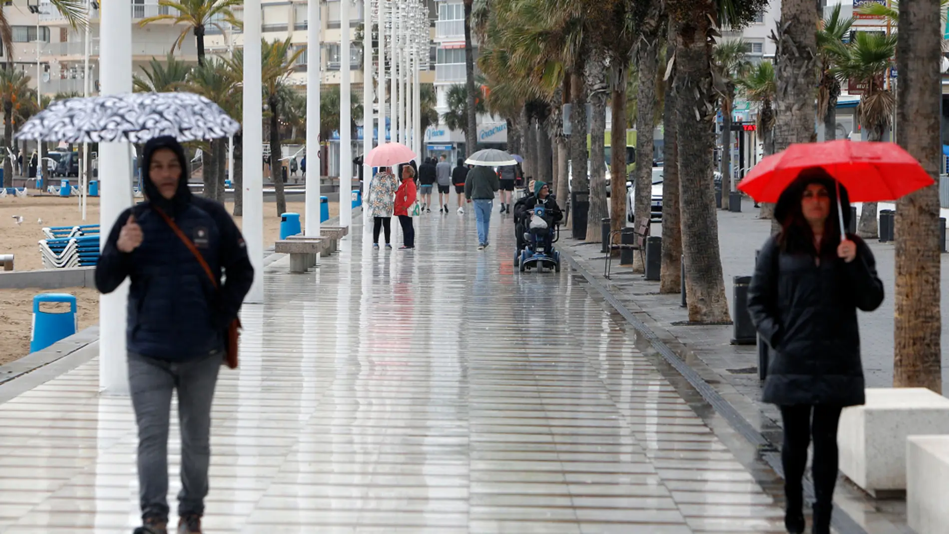  Turistas bajo la lluvia en el paseo de Benidorm